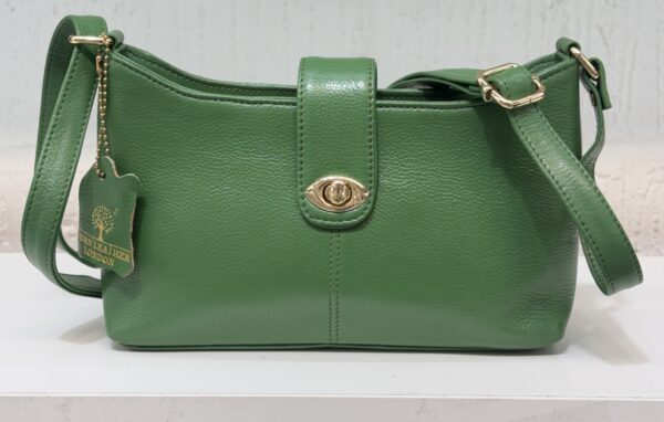 Green leather handbag with gold-tone hardware and an adjustable strap resting on a white surface.