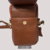 Brown pebbled leather mini bag with open front flap and gold snap, showing strap attachments and zipper detail on the side.